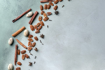 Tasty pecan nuts with spices on light background