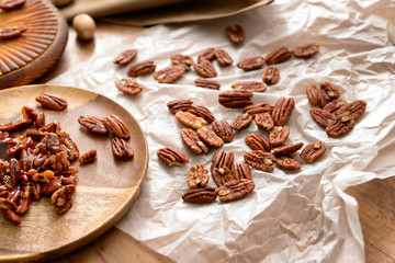Candied and raw pecan nuts on wooden table