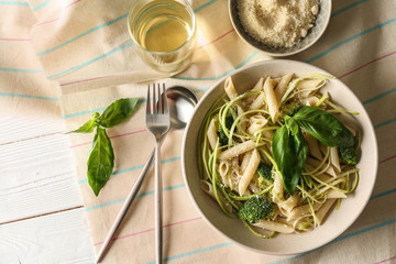 Plate with tasty pasta and green vegetables on white table