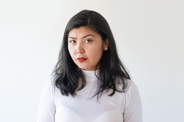 Sad angry girl looking at camera. Closeup of serious strict young Asian woman. Problems concept