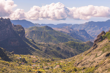 Mountain landscape with green hills and white clouds. Valley wit