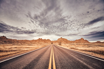 Scenic road in Badlands National Park, color toned picture, South Dakota, USA.