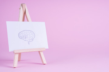 Sketch hand drawn brain on small decorative easel.