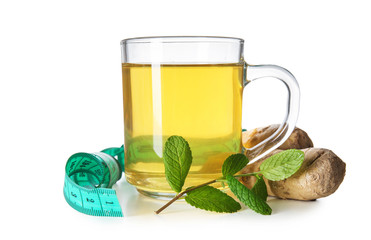 Cup of tea with ginger and measuring tape on white background. Weight loss concept