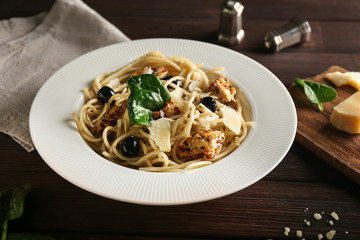 Tasty pasta with meat, olives and cheese on plate