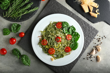 Plate of tasty color pasta with tomatoes on table