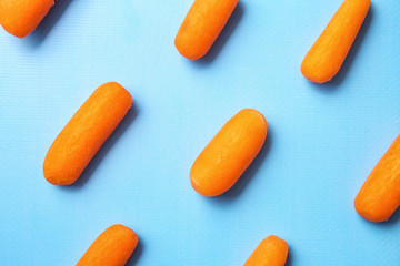Many baby carrots on color background
