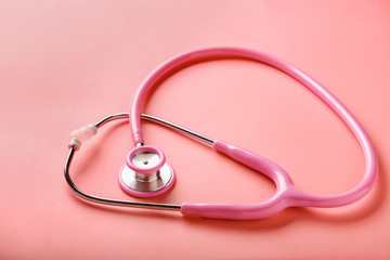 Medical stethoscope on coral background