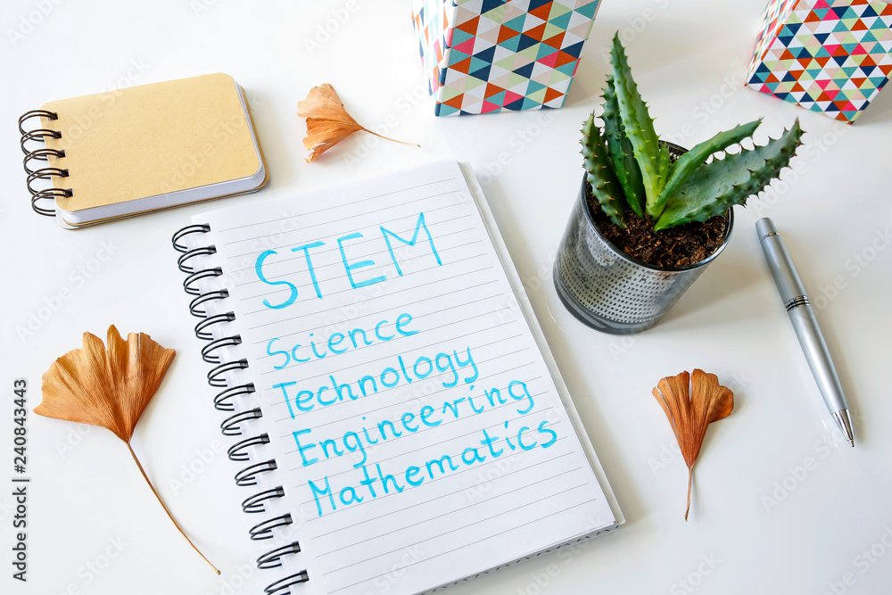 Aufkleber stem science technology engineering and mathematics written in a notebook on white table