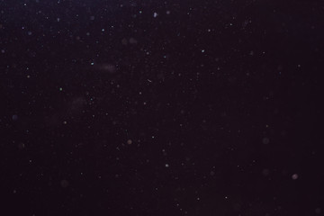Dust in the air illuminated by light on a dark background