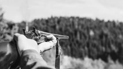 Hunter with retro shotgun aims at the target. Hunting season