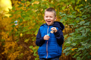 Little boy playing with soap bubbles, outdoor