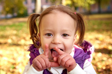 Little girl child enjoying playing in autumn park