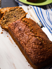 Banana bread loaf sliced on wooden board