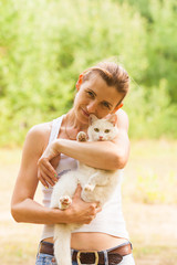 Obraz premium Woman holding white cat in summer park