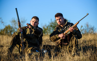 Discussing catch. Hunters with rifles relaxing in nature environment. Hunter friend enjoy leisure...