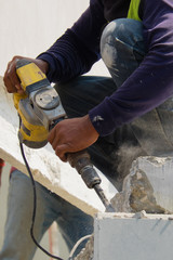 Construction worker use electric drill Drilling concrete wall in construction area, Precast house construction.