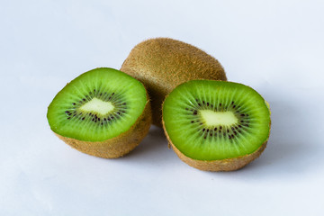 Kiwi partido en dos y uno entero con fondo blanco