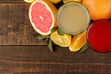 Citrus juices. Lemon and grapefruit juice with fresh fruit on a brown wooden table. with space for text. view from above