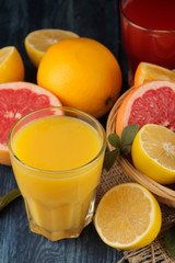 Citrus juices. Orange juice with fresh fruits on a blue wooden table. close-up