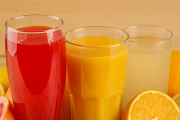 Citrus juices. orange, lemon and grapefruit juice with fresh fruits on a natural wooden background.