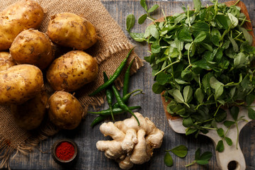 Potatoes, Fenugreek, Green Chillies and Ginger on a Chopping Board