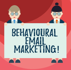 Text sign showing Behavioural Email Marketing. Conceptual photo customercentric trigger base messaging strategy Male and Female in Uniform Standing Holding Blank Placard Banner Text Space