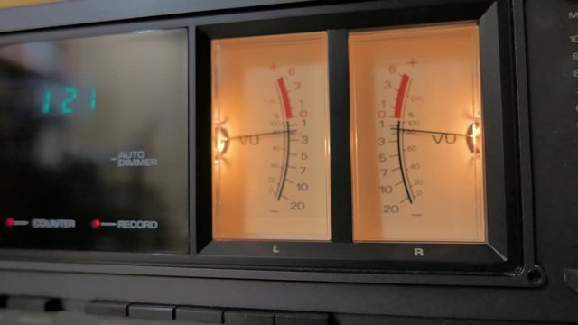 Close up of sound meters on a analogue tape machin. the camera rotates around them