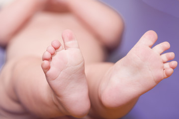 Baby's bare feet close up on blue