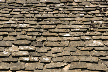 Old stone roof tiles covered with lichens and mosses background texture