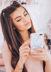 Portrait of beautiful young brunette girl with a mobile telephone in a hand
