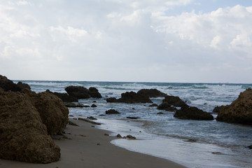 Waves crashing on shoreline with moody dramatic sky
