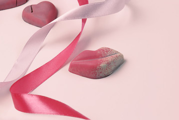 On the table are figures in the shape of a heart and lips, ribbons. Holiday concept or greetings. Selective focus, place for text.