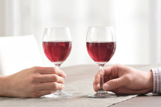 ワインで乾杯するカップルの手