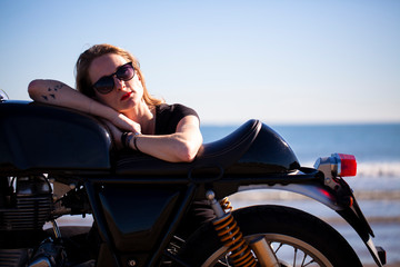 Mujer apoyada en su motocicleta