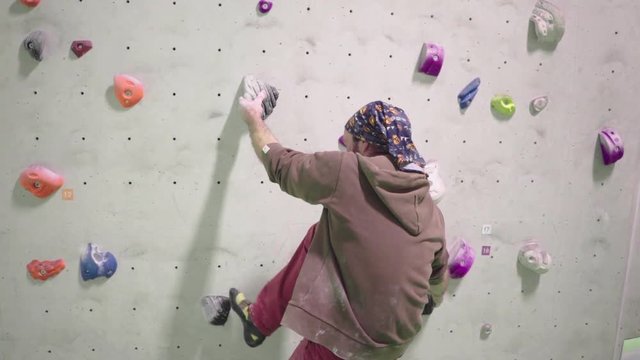 indoor climber climbing bouldering exercise leisure wide shot gimbal man slow motion