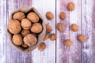 Walnuts top view photo, walnuts are in jute sack bag on wooden table