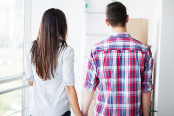 Obraz premium New Home. Funny young couple enjoy and celebrating moving to new home. Happy couple at empty room of new home