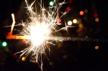 sparkler on Christmas tree lights background