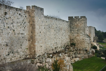Fototapeta na wymiar Medieval walls of Jerusalem. Ancient stone, gloomy sky.