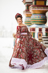 Beautiful happy woman is wearing traditional russian costume in winter