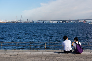 港の公園で語り合う二人の男女