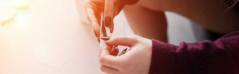 partial view of girl sitting and rolling marijuana joint at home