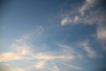The bright background of the sky is covered with beautiful clouds. Very light clouds and sky soar across the horizon. Wind accelerates paint with a blue background image of nature.