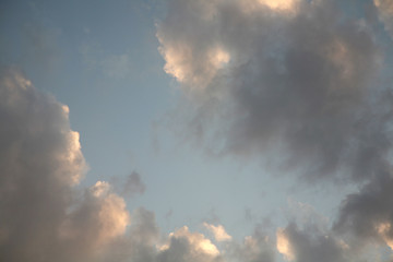 The sun  rays illuminate the sky with clouds. We see the background of the sky of natural color as in the picture. This image of a beautiful sky and white clouds pleases all people.