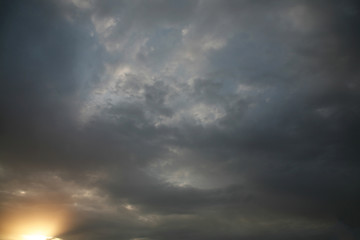 Sky background beautiful image. Abstract background is decorated with different types of clouds. Sunset in the evening sky. The sun  rays illuminate the clouds.