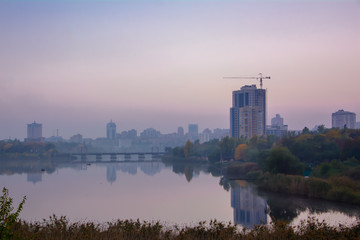 The view of the embankment of the Kalmius river in a lilac mist