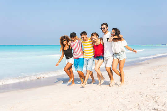 Group of friends walking on the beach