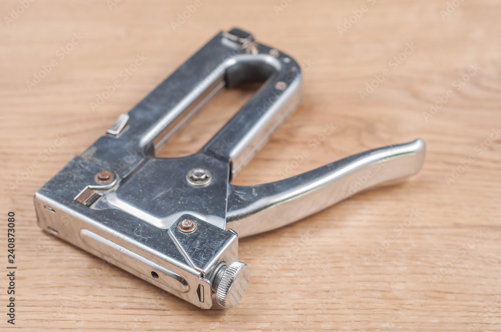 Wall mural construction stapler on wooden background