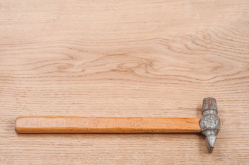 Small hammer on a wooden background